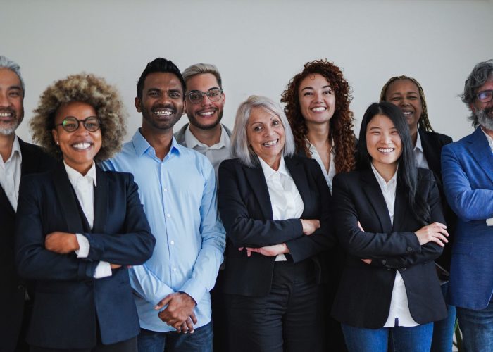 Group of happy multiethnic business people smiling on camera inside office